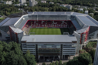 Luftaufnahme des Fritz-Walter-Stadions in Kaiserslautern mit vier Tribünen, Glasfassaden, Solarpanels und umliegender Wohnbebauung.